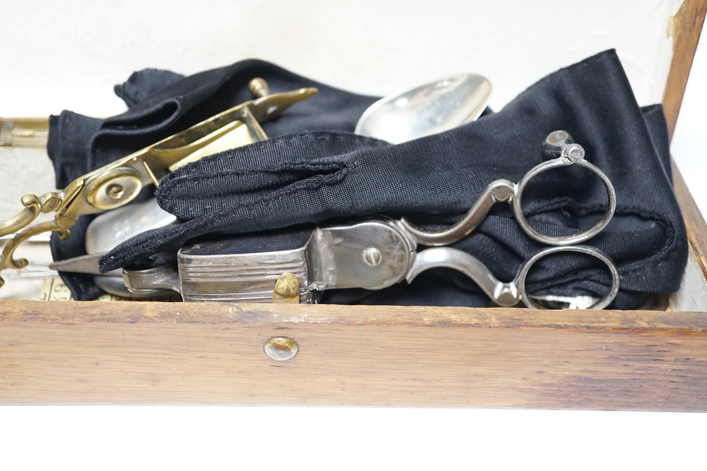 A glove box containing a boxwood foot-measure, two candle snuffers, a silver teaspoon etc